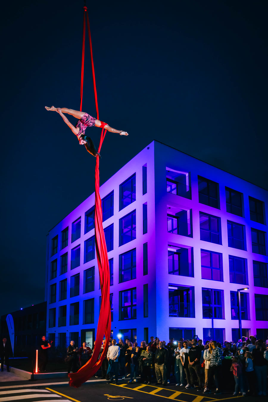 Aerial silks performance by a female aerialist suspended high above the stage