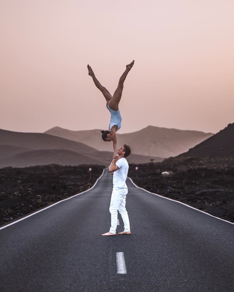 Handstand balance on an empty road with pink-toned mountains in the background