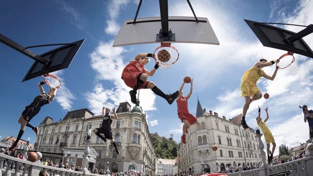 Four athletes dunking at several hoops at once on a bridge in the centre of Ljubljana