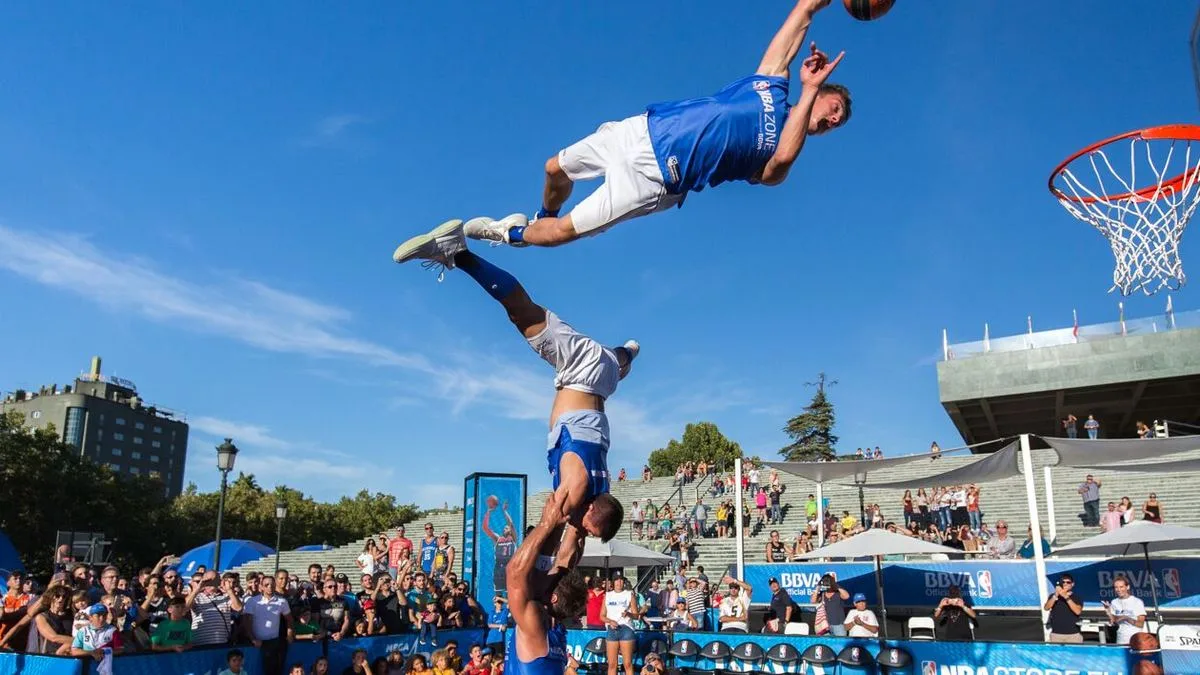 Dunking Devils athlete performing a flip slam dunk off a trampoline at an NBA halftime show